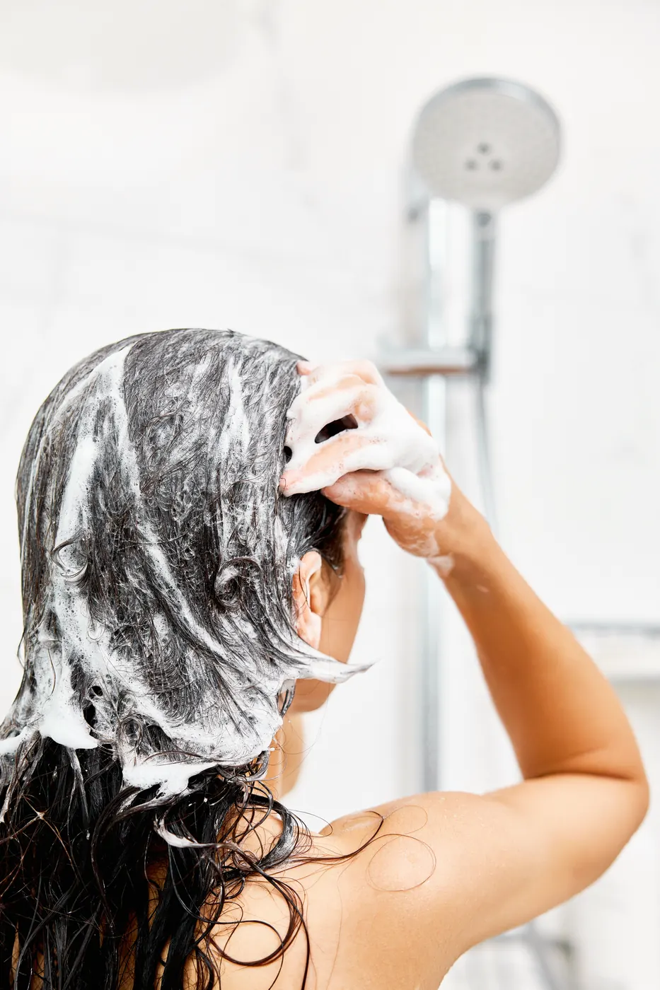 Pessoa lavando o cabelo com shampoo